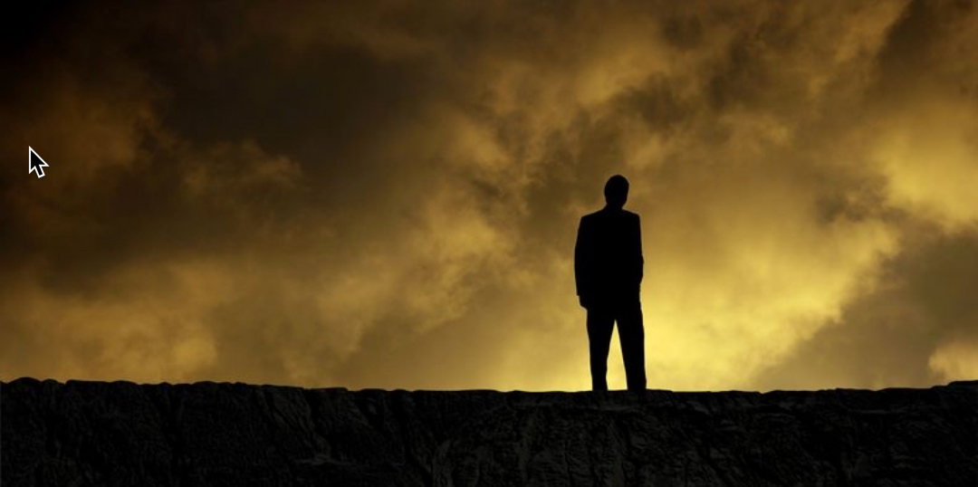 Silhouette of person with dark clouds behind them