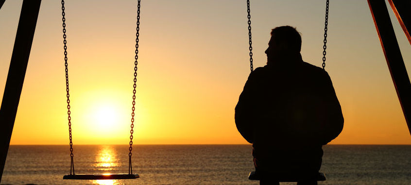 Man at sunset on swing